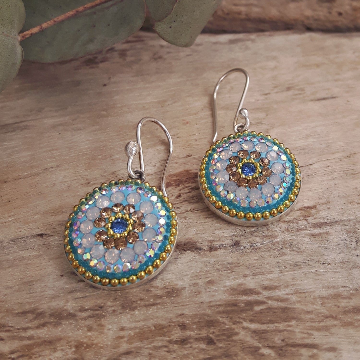 close up daisy coin earrings crystal detail laid flat